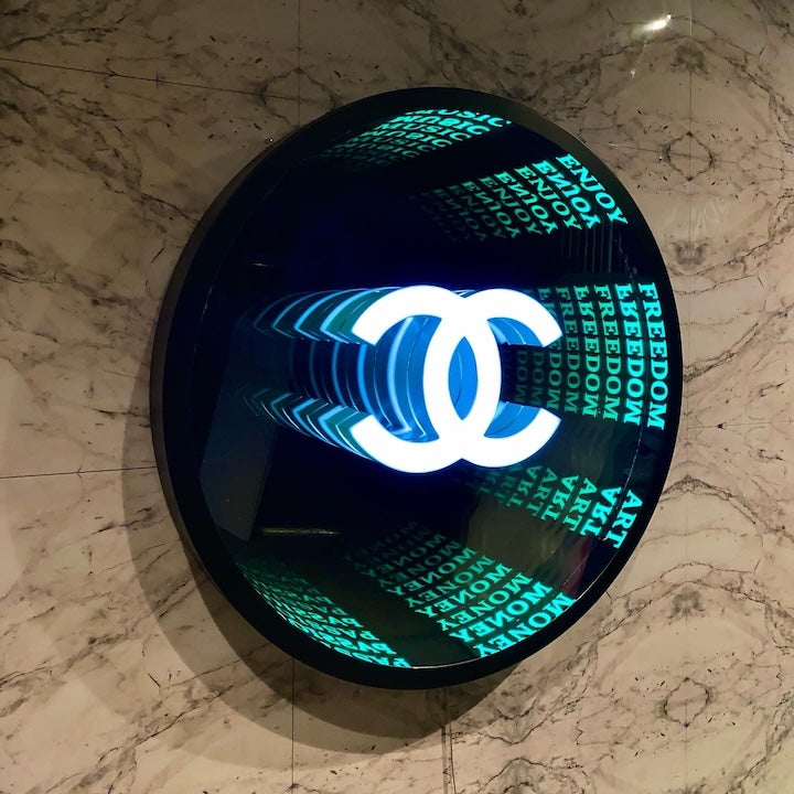 A Custom Logo Infinity Mirror displays a glowing Chanel logo on marble with repeated words like FREEDOM, ART, and ENJOY.