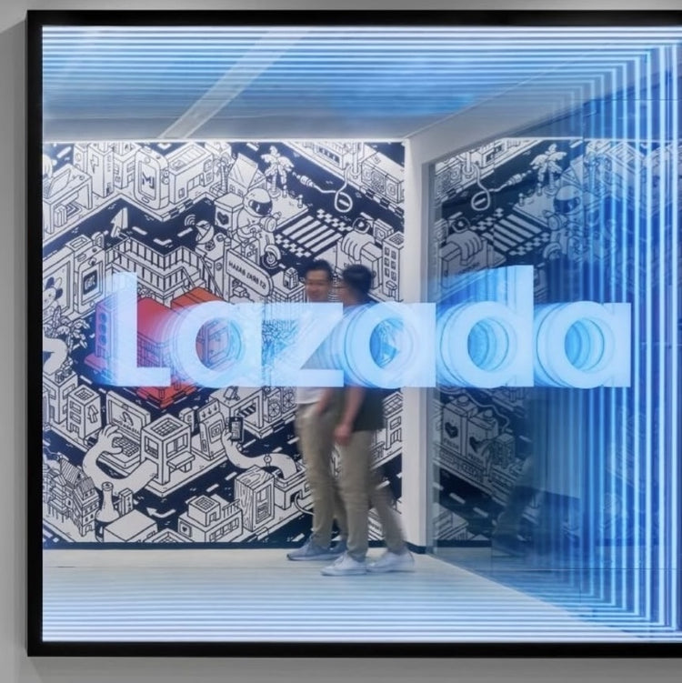 Two people walk past a Custom Logo Infinity Mirror with blue neon lights and a city mural in the background.