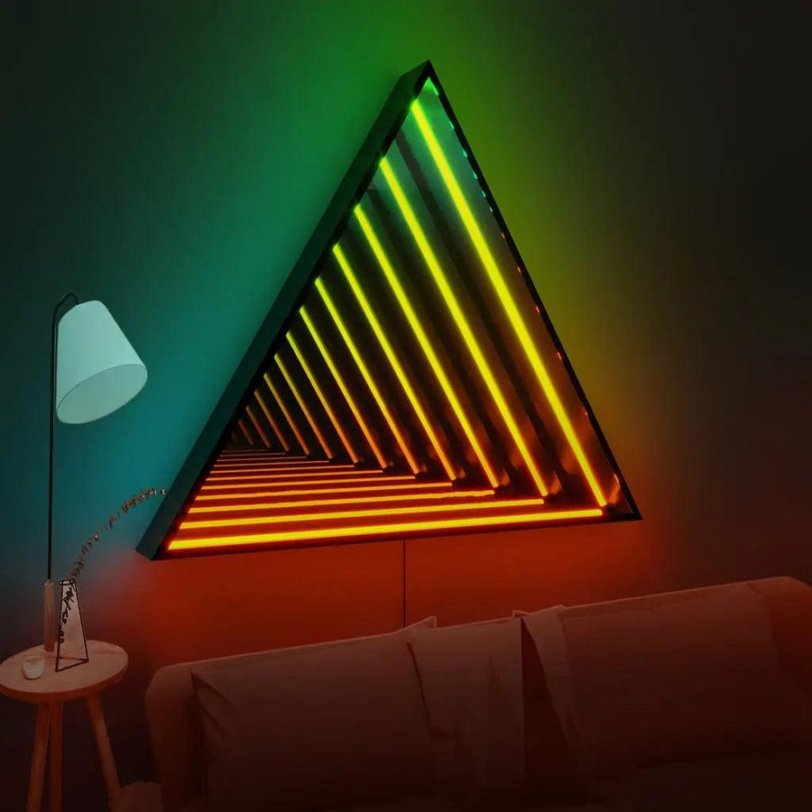 The Maytrix Triangle Infinity Mirror features glowing green, yellow, and orange neon bars for a striking modern touch above a sofa, while a nearby side table with lamp and plant provides customizable lighting and soft ambiance.