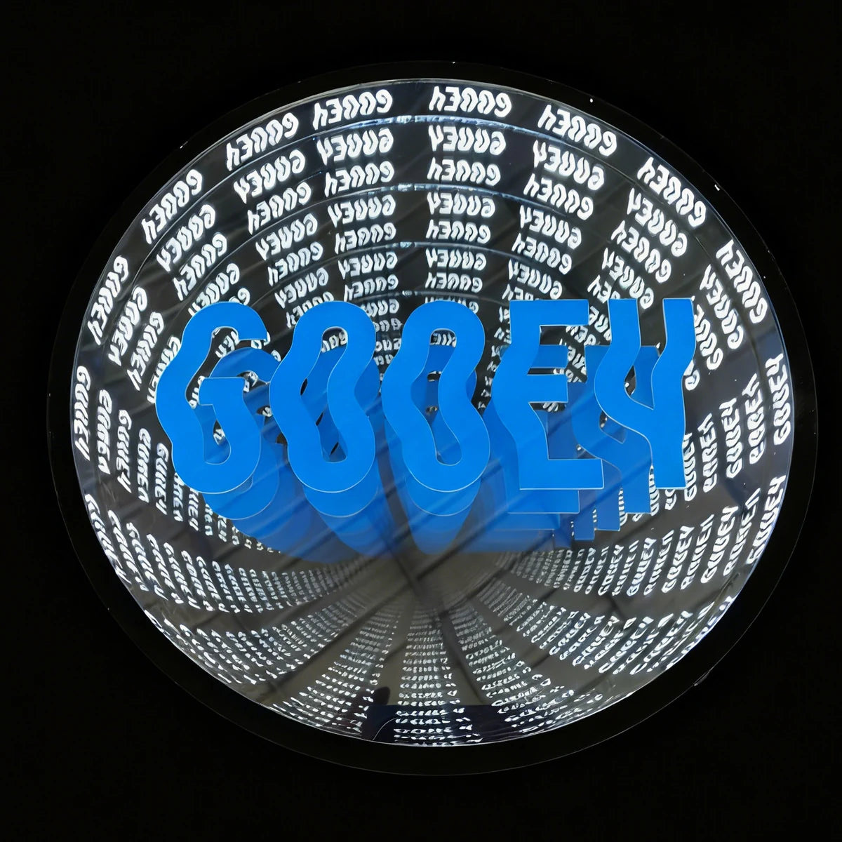 Finished circular infinity mirror with blue lettering, repeating artwork and a dark outer frame.